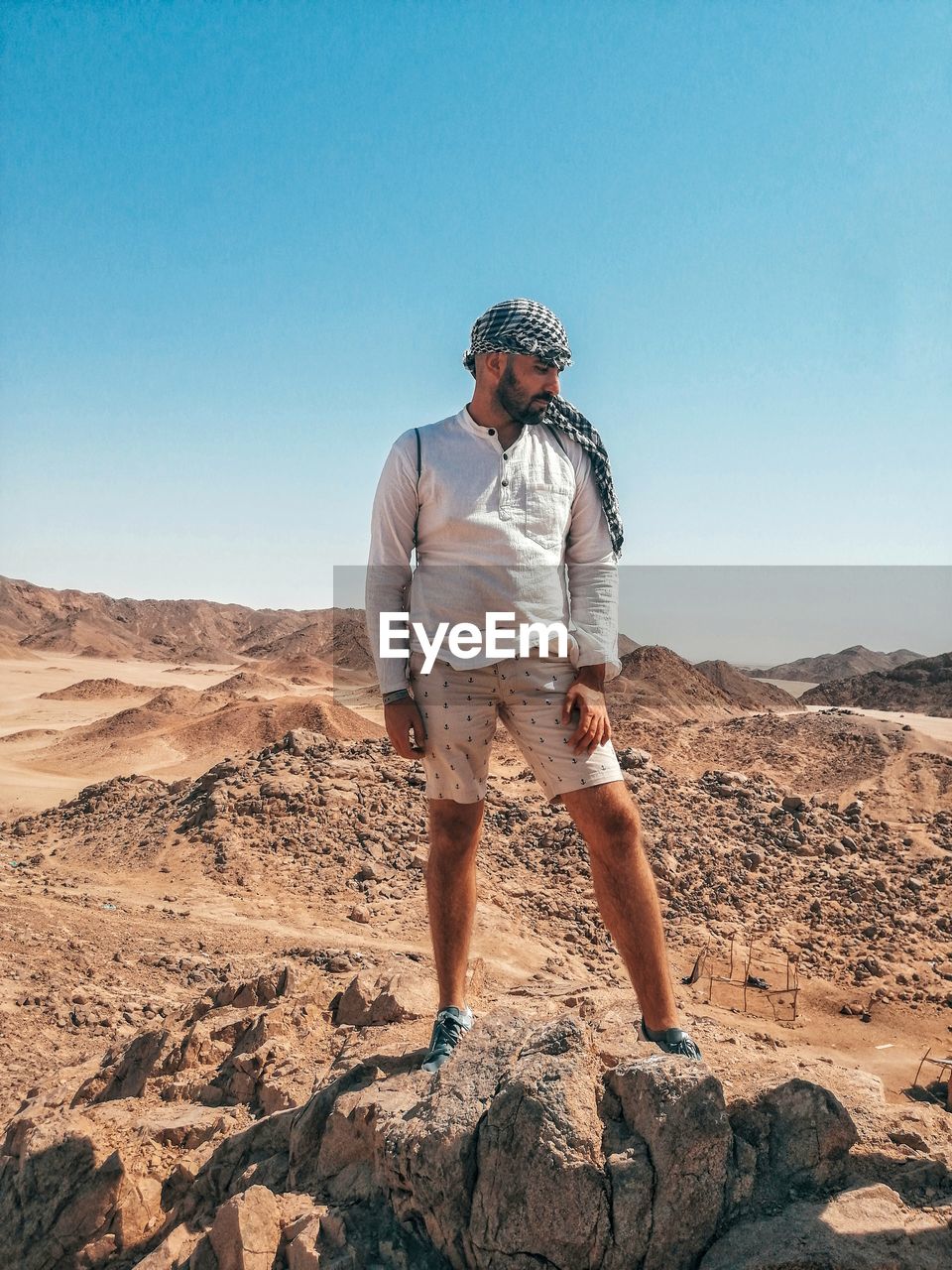 Midsection of man standing on land against clear sky