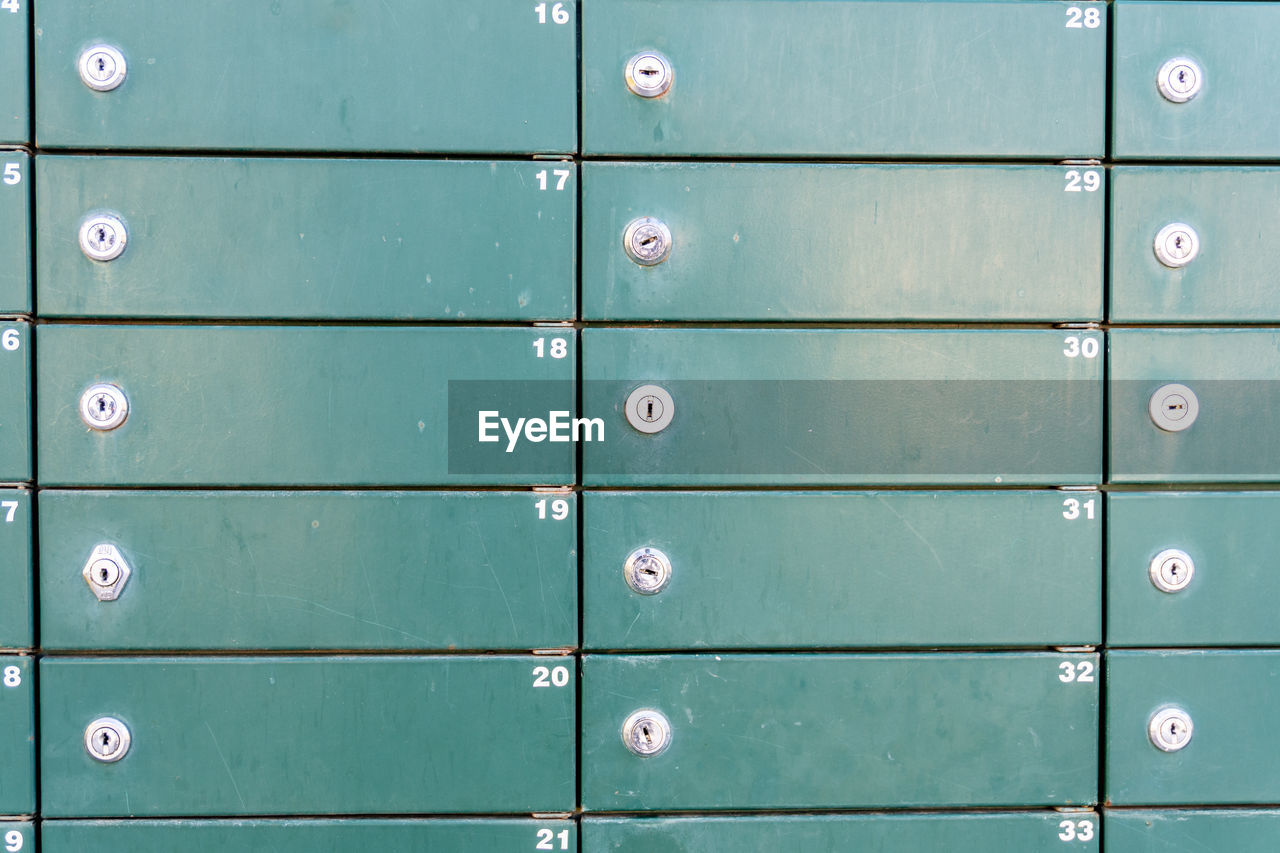Close-up of some green metallic mailboxes.