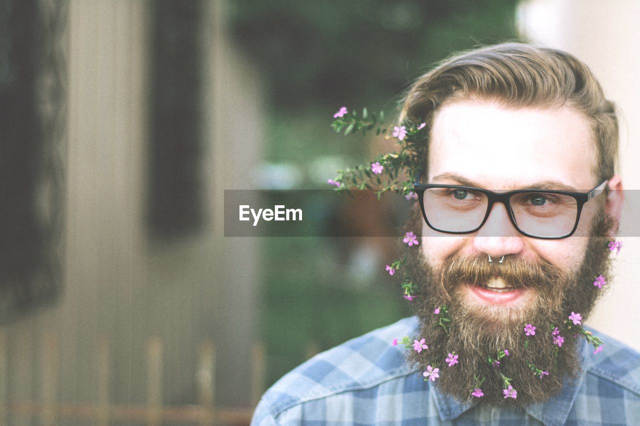 Close-up of smiling hipster wearing flowers