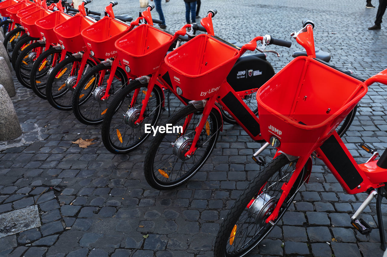 HIGH ANGLE VIEW OF RED BICYCLE PARKED ON FOOTPATH