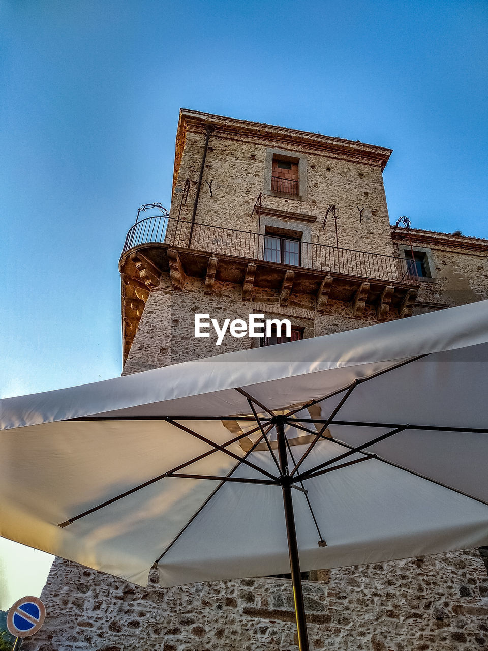 Low angle view of building by parasol