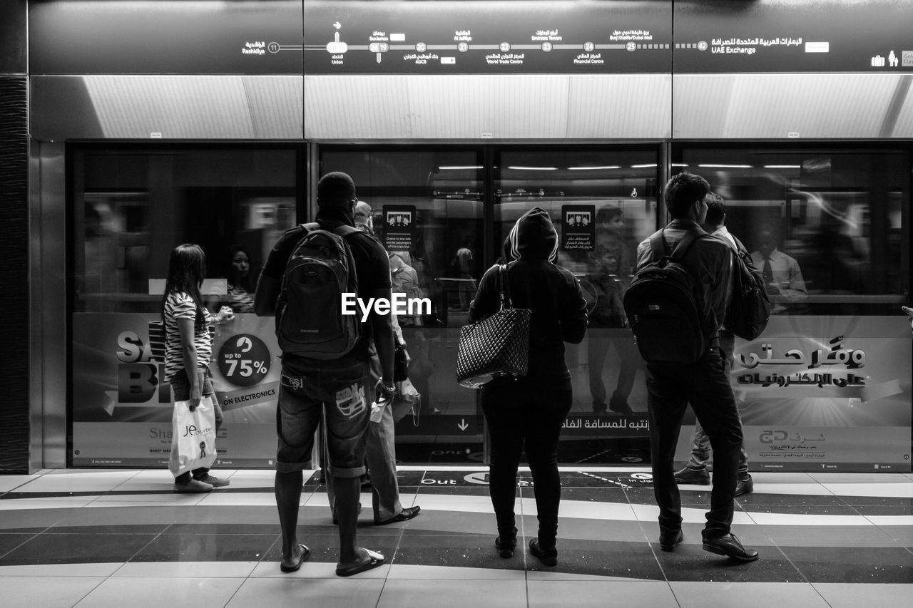 REAR VIEW OF PEOPLE AT RAILROAD STATION