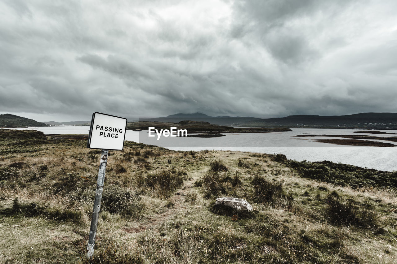 SIGN ON LANDSCAPE AGAINST SKY