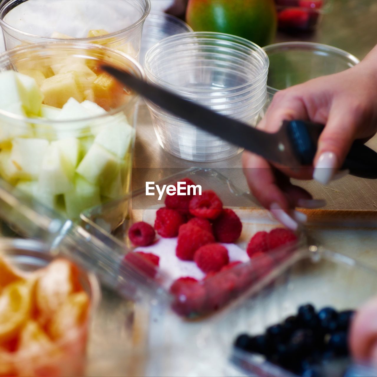 CROPPED IMAGE OF HAND HOLDING STRAWBERRIES