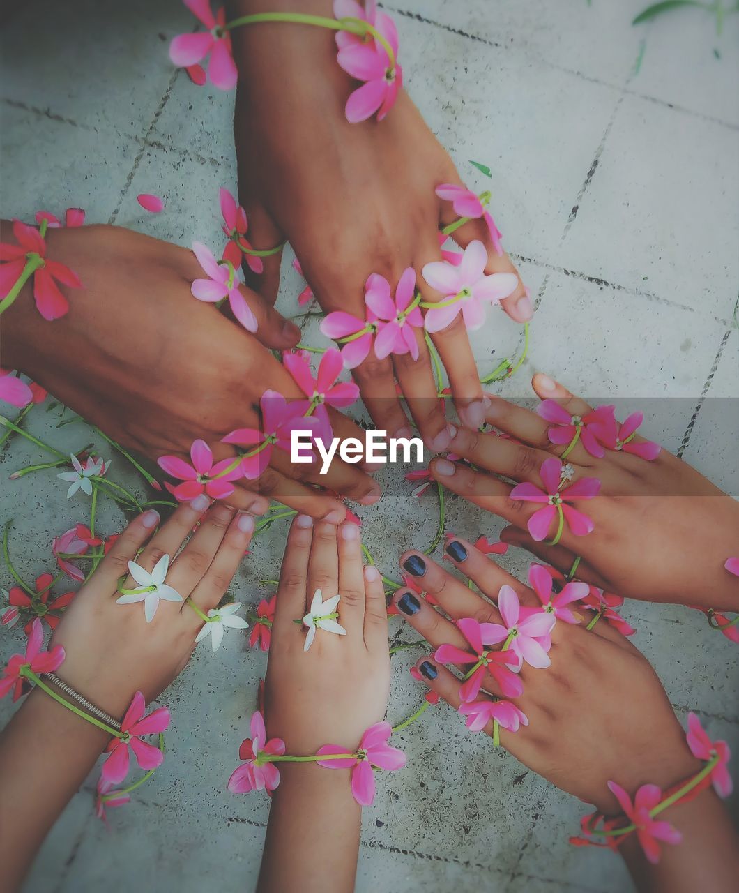 Close-up of hands with flowers over floor