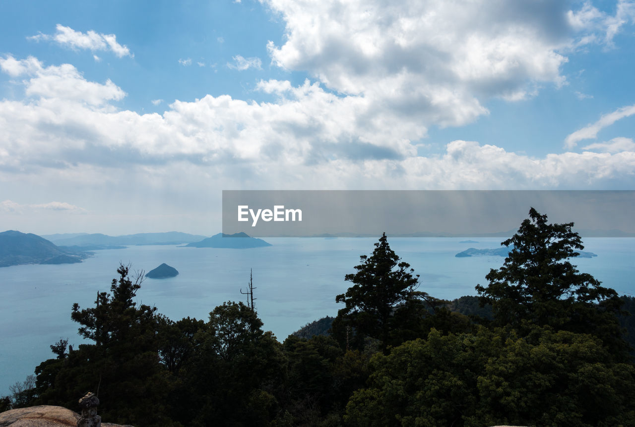 Scenic view of trees and mountains against sky
