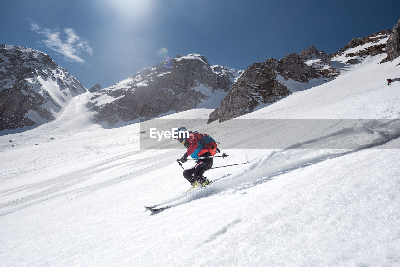 Low angle view of man skiing on snow covered mountain