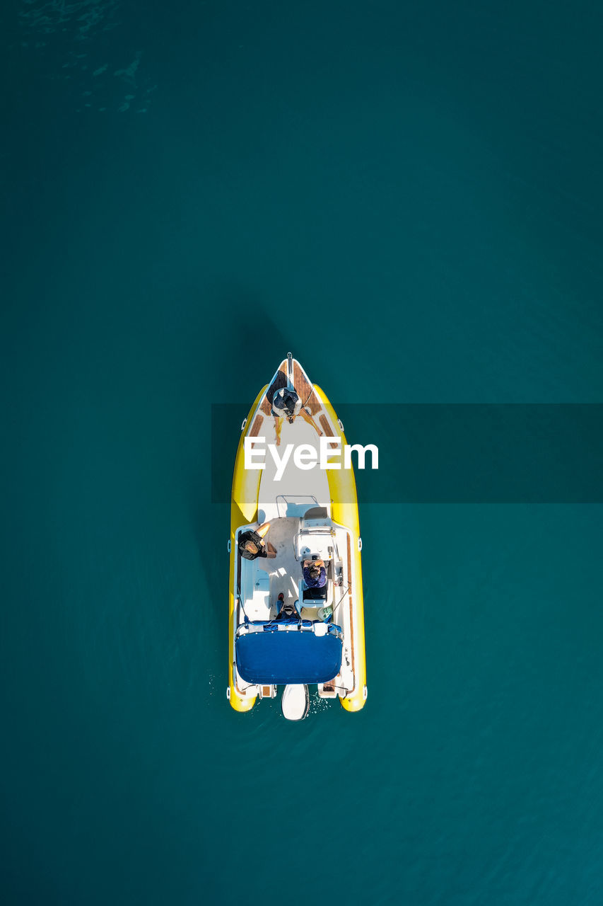 HIGH ANGLE VIEW OF PEOPLE SAILING ON BOAT