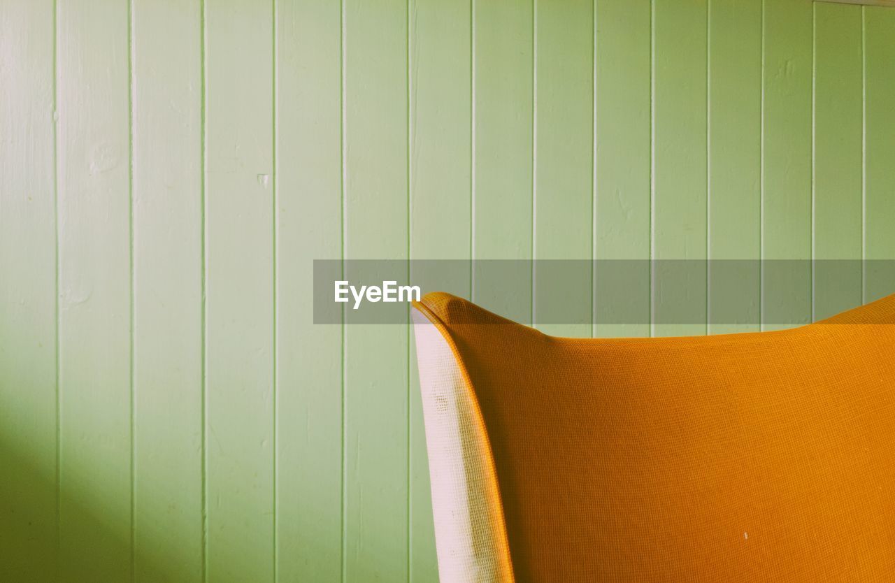 Orange sofa against wall