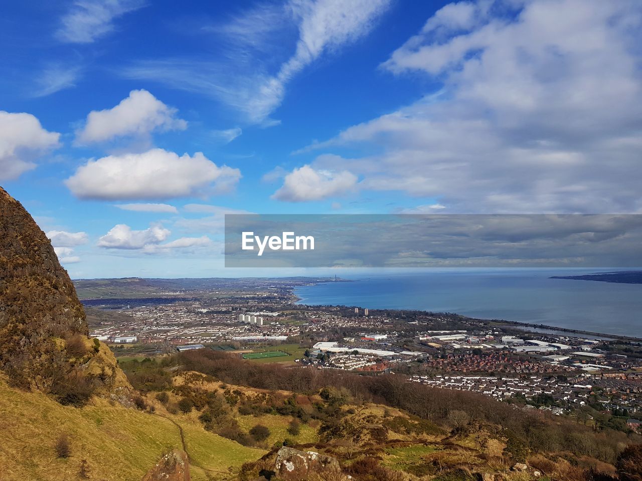 Aerial view of city by sea against sky