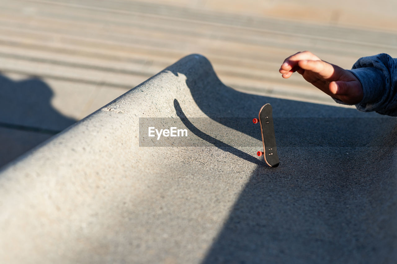 Riding a mini skateboard or fingerboard on outdoors ramp