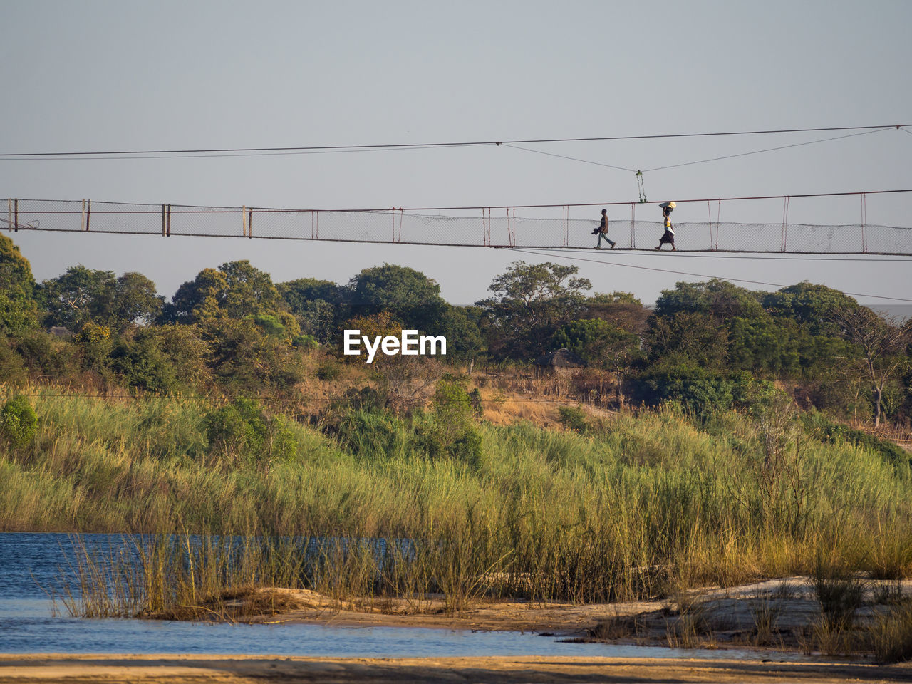 Scenic view of local people walking on foot bridge over zambezi river, zambia
