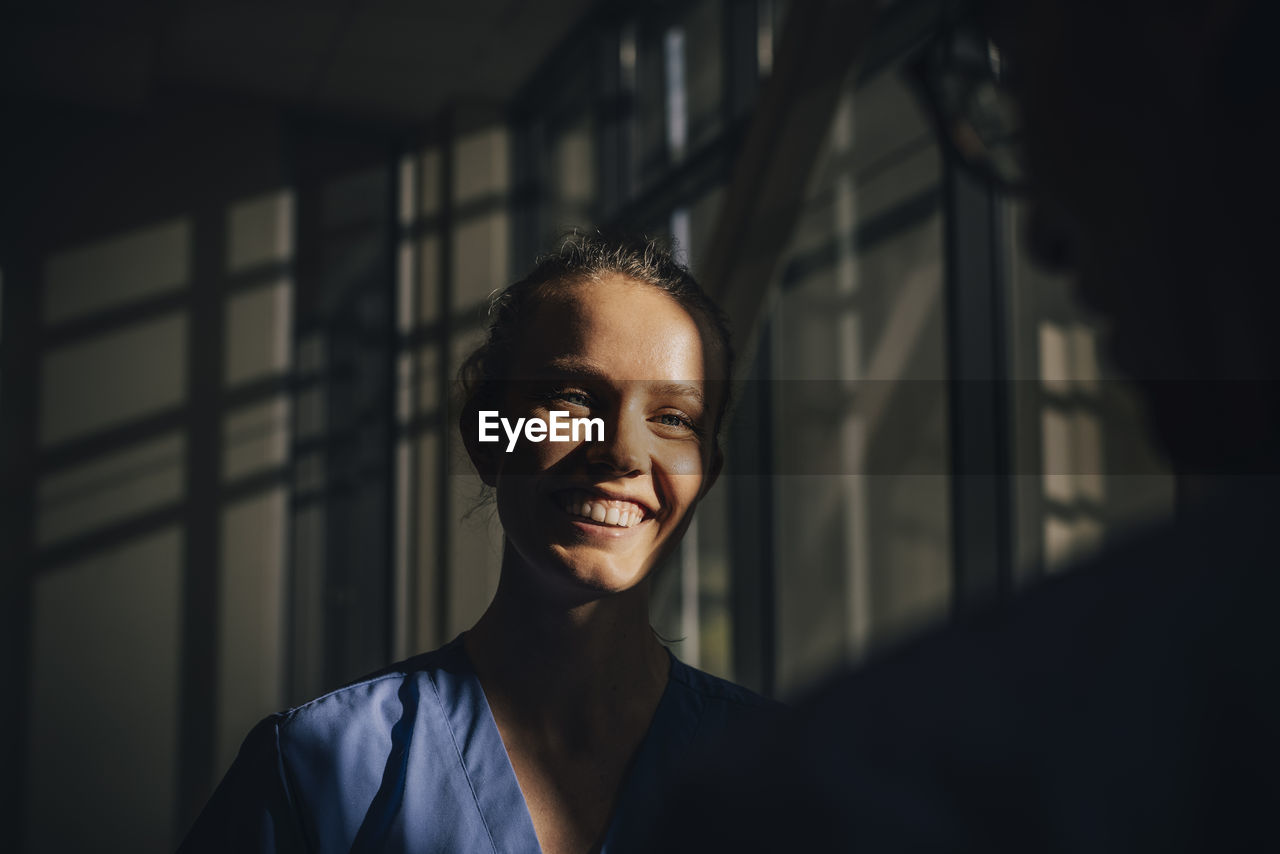 Sunlight falling on face of happy nurse in hospital