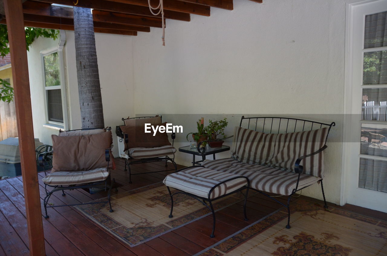 Empty chairs and table against building