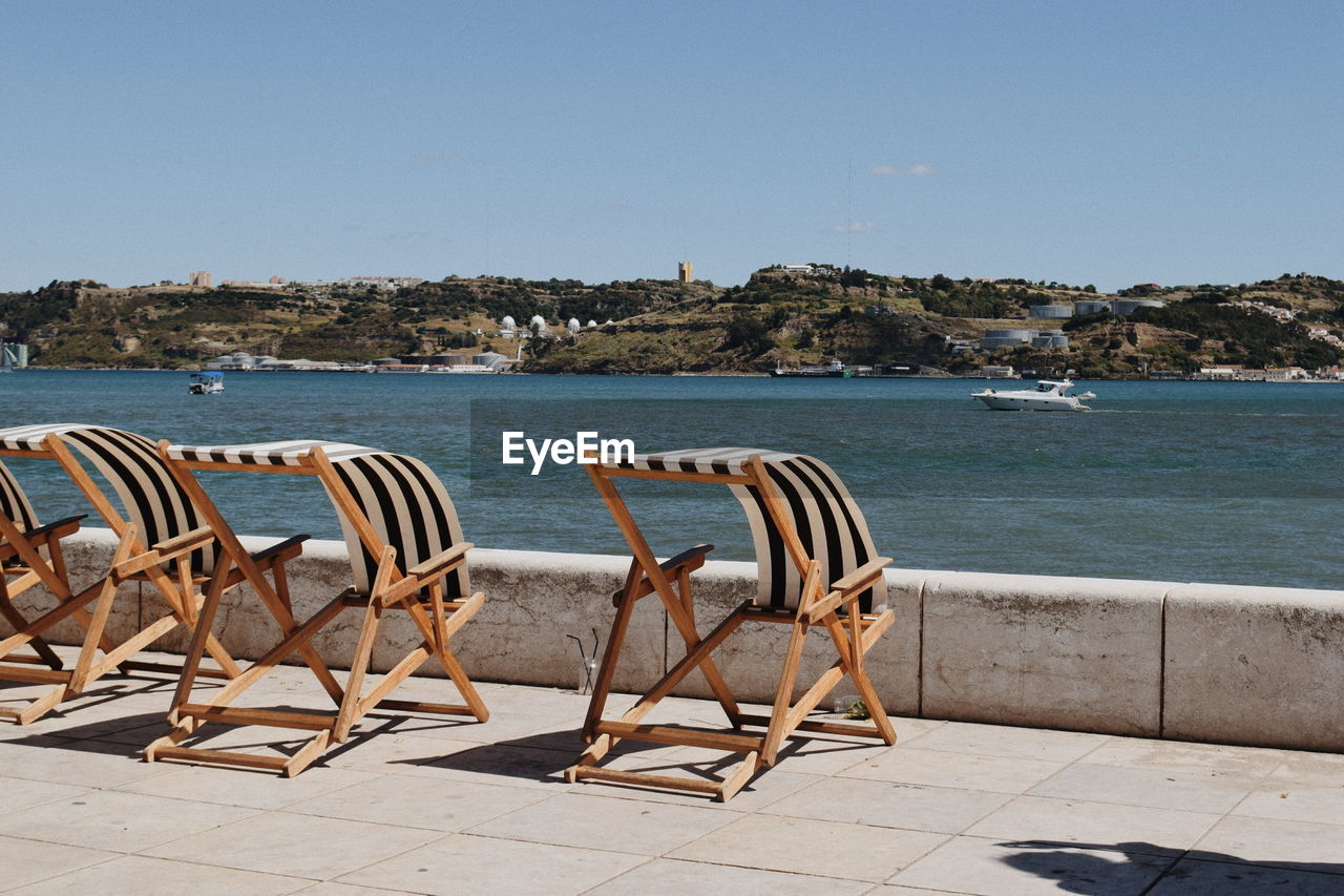 CHAIRS BY BEACH AGAINST CLEAR BLUE SKY