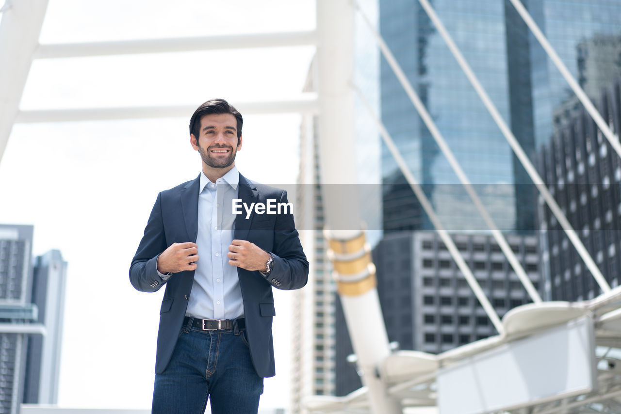 portrait of businessman standing against built structure