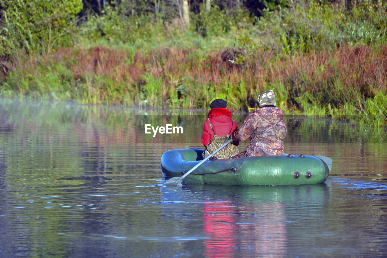 TWO PEOPLE SITTING IN WATER