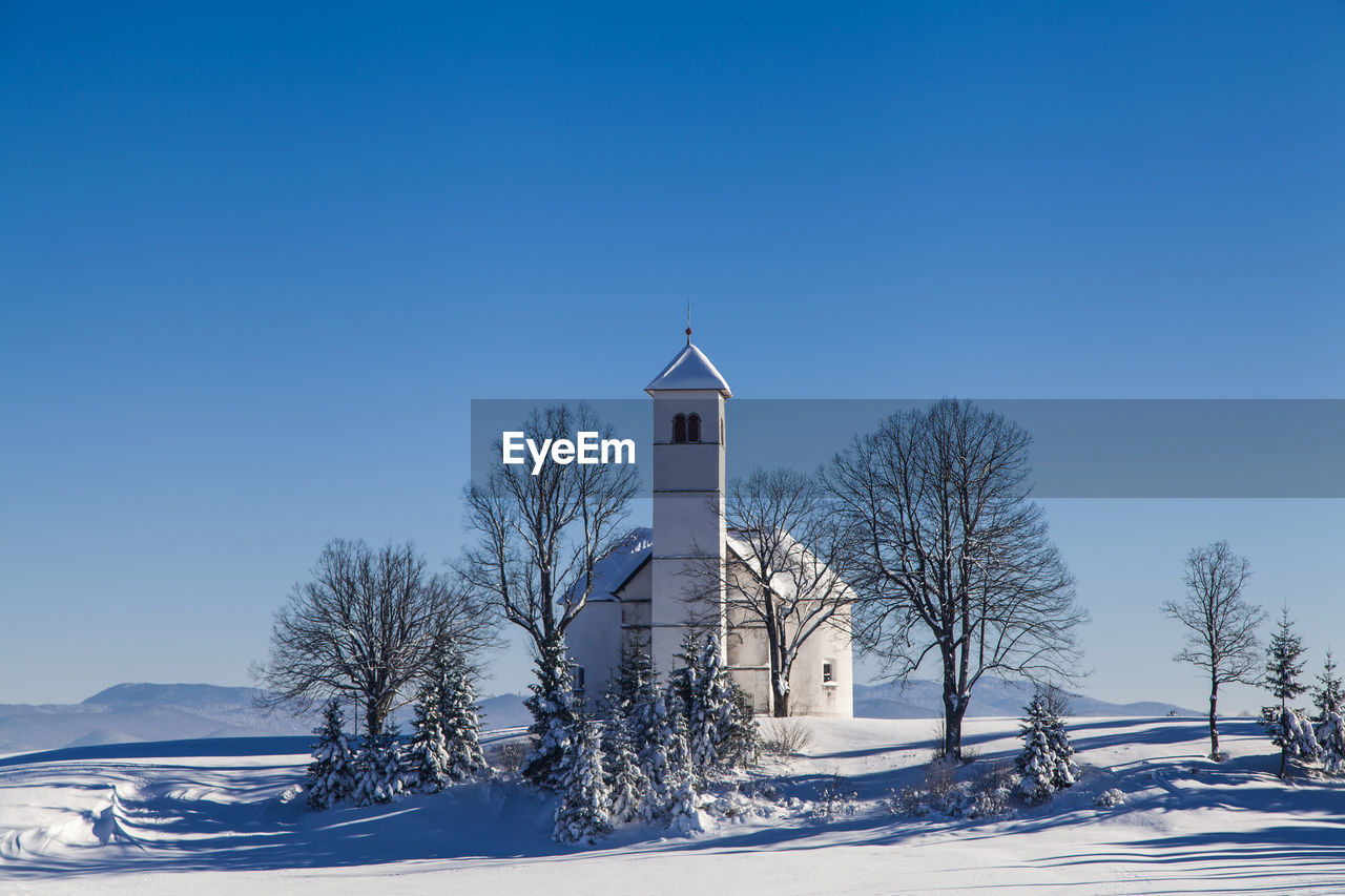 BUILT STRUCTURE ON SNOW COVERED LANDSCAPE AGAINST CLEAR SKY