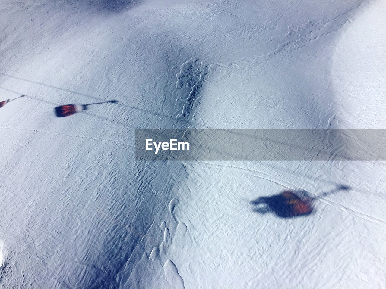 HIGH ANGLE VIEW OF SNOW ON ASPHALT