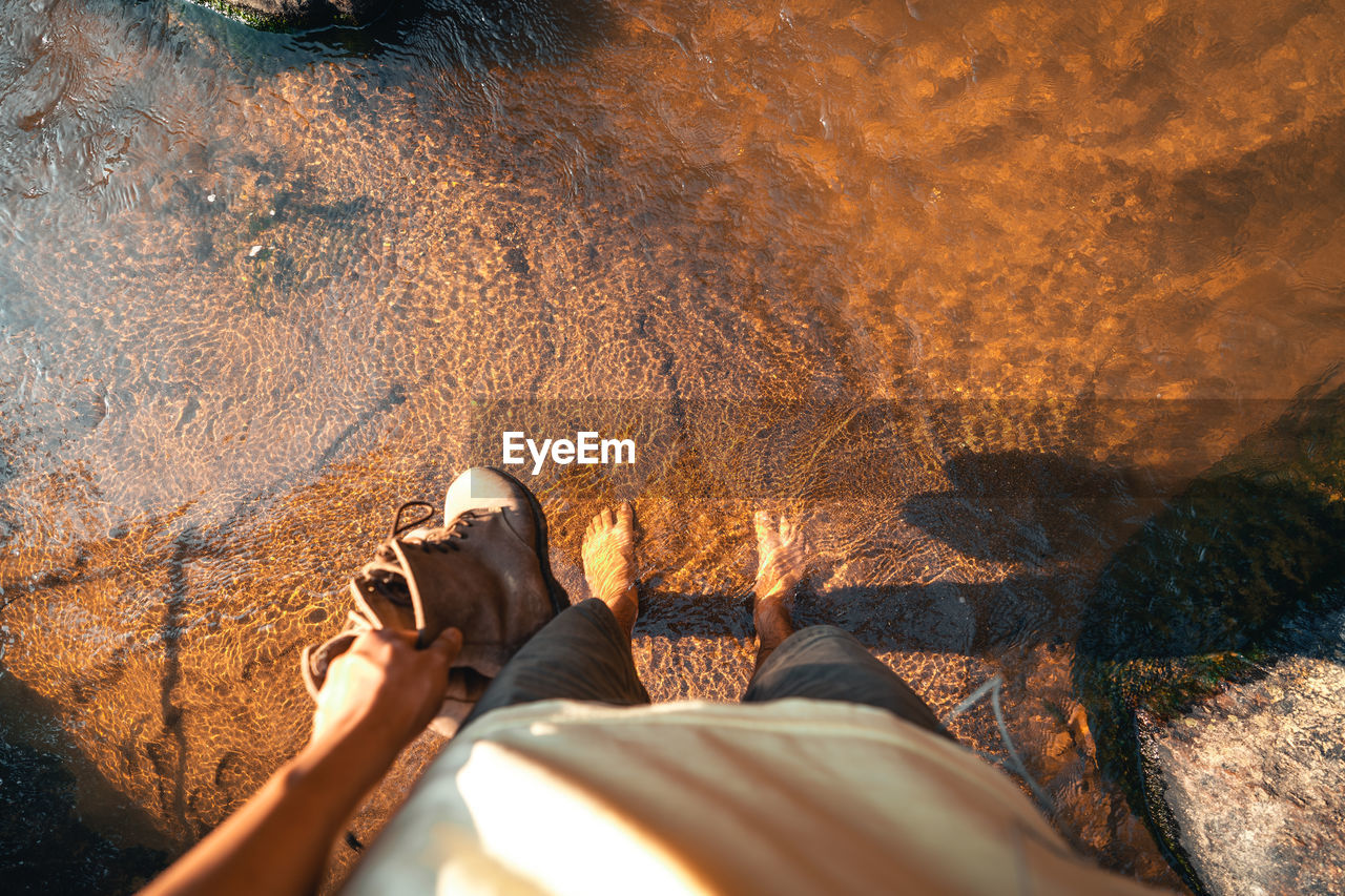 Low section of woman standing in river