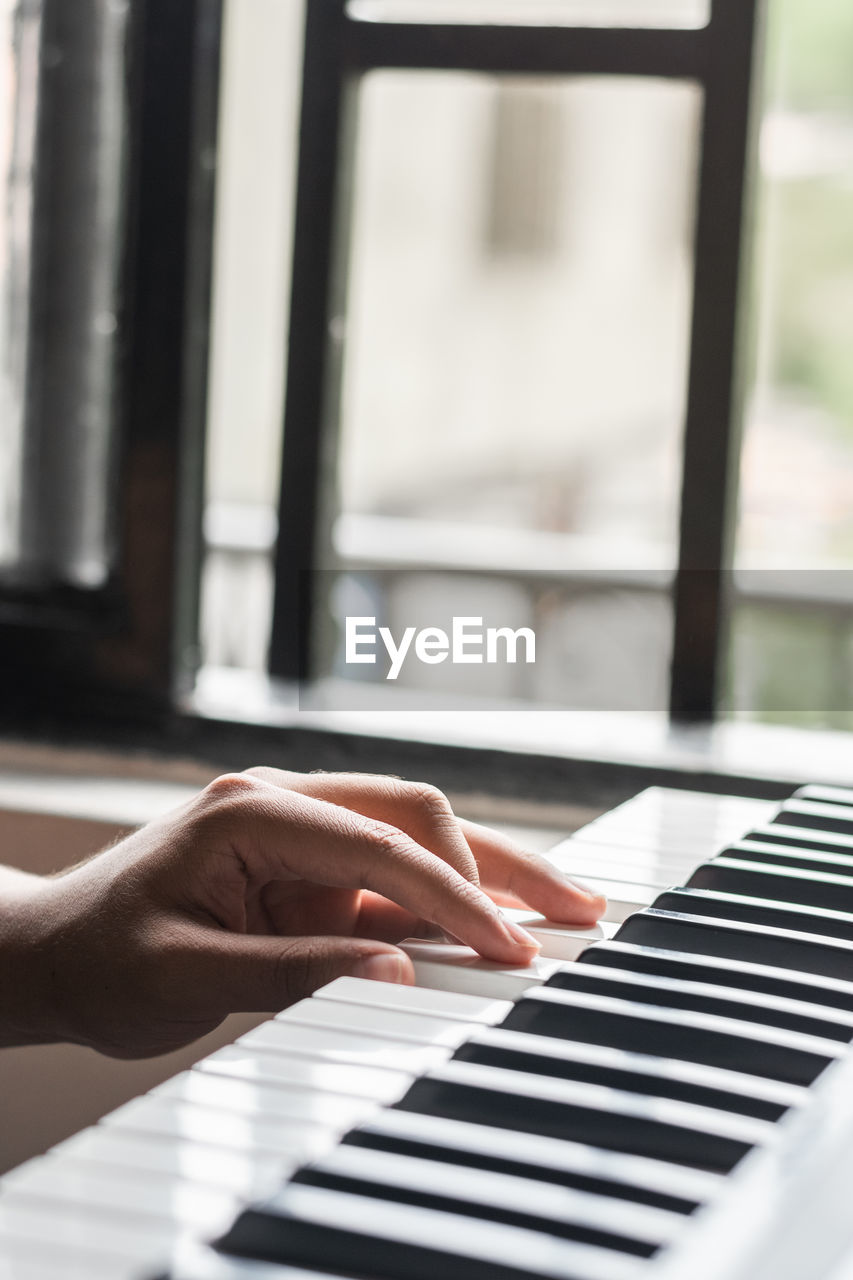 Cropped hand playing piano