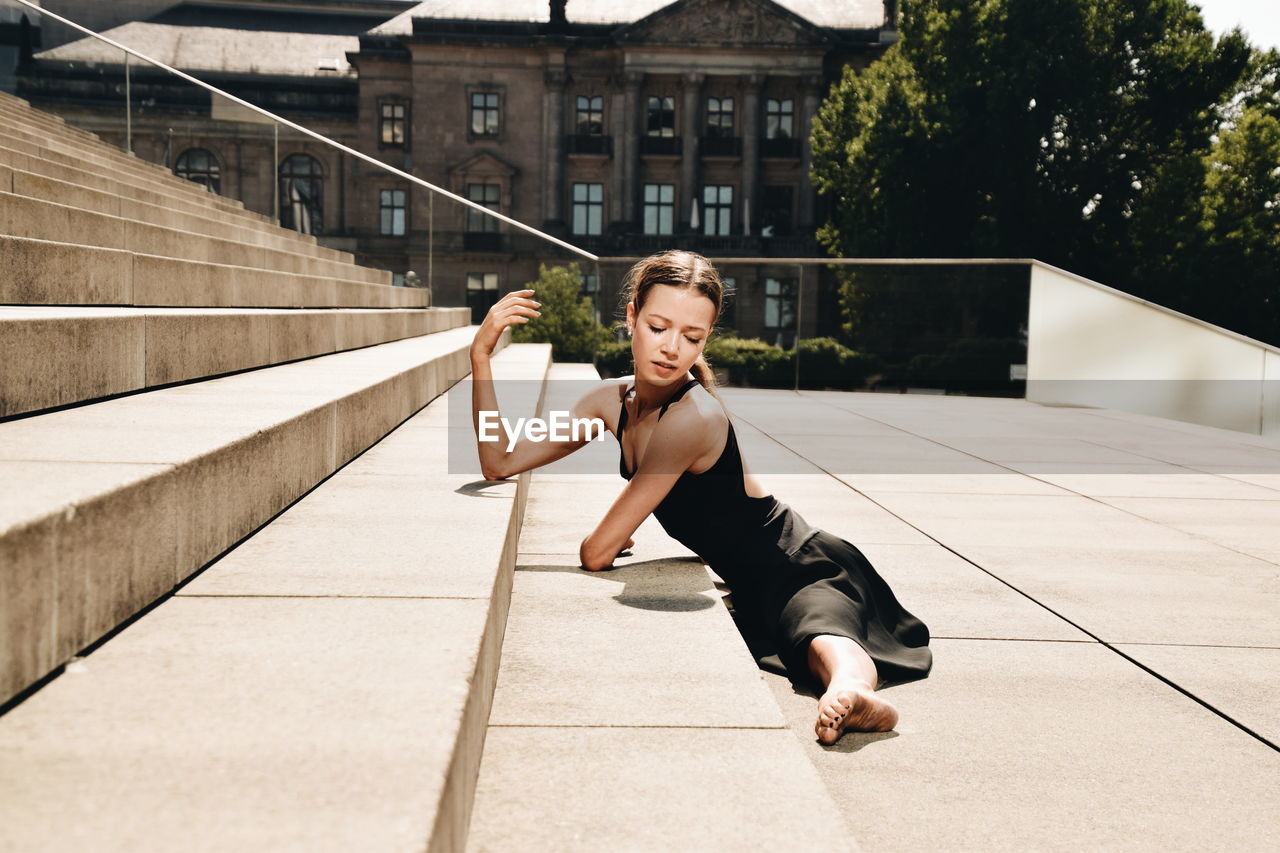 PORTRAIT OF YOUNG WOMAN ON RAILING