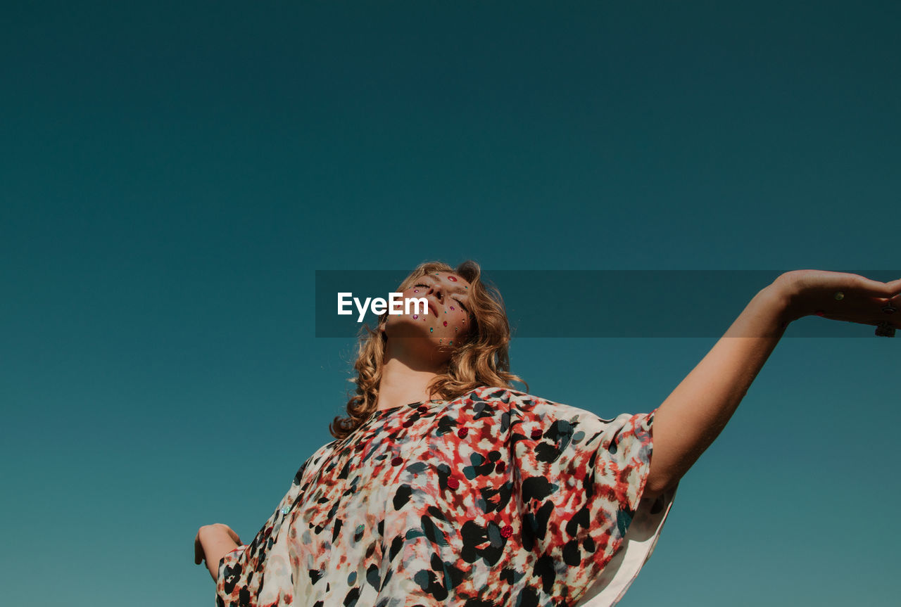 Woman with make-up against clear sky