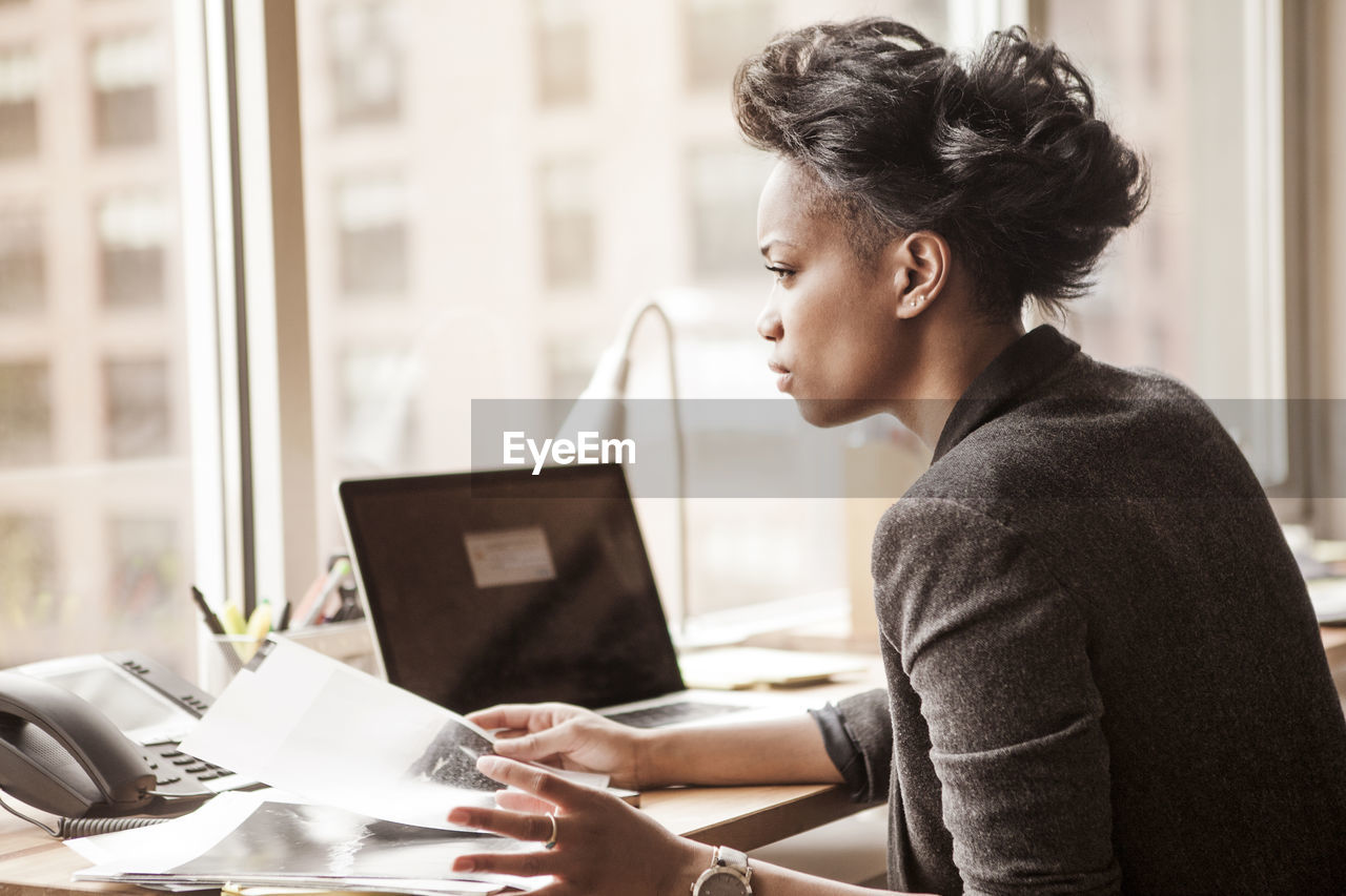 Businesswoman sitting at table in office