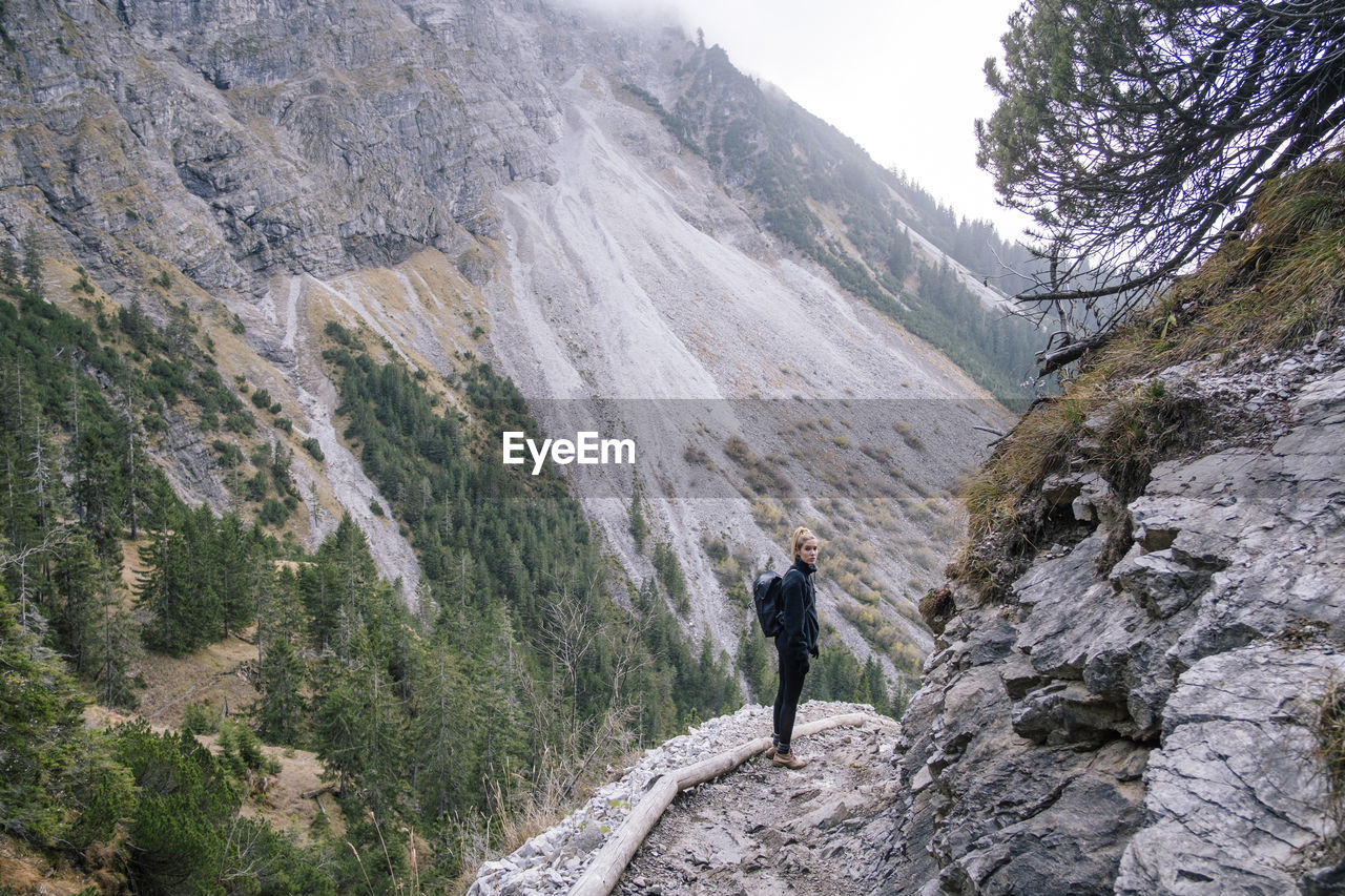 Full length of woman standing on mountain ridge