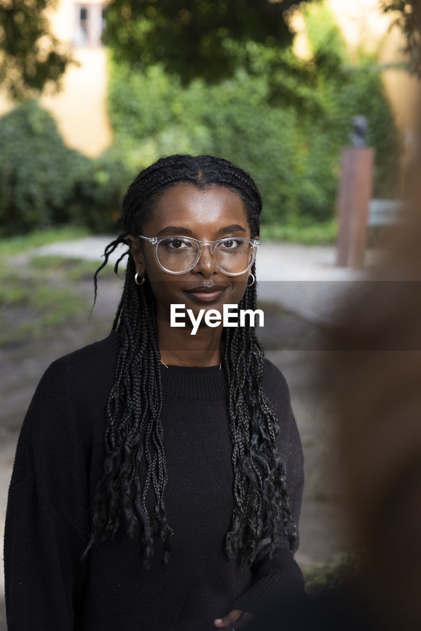 Portrait of smiling woman with braided hair at park