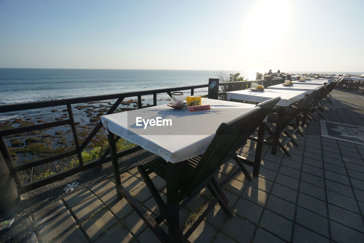 Empty tables overlooking calm sea