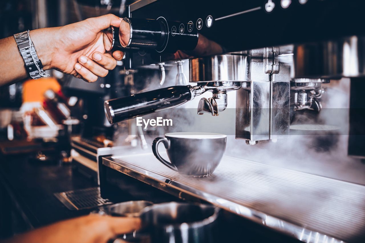 hand, espresso machine, indoors, coffeemaker, food and drink, occupation, adult, coffee, espresso maker, barista, business, cafe, one person, person, coffee shop, drink, making, working, drums, pouring, restaurant, appliance, skill, refreshment, men, coffee cup, close-up, selective focus, small business, motion, metal, hot drink, cup, expertise, heat