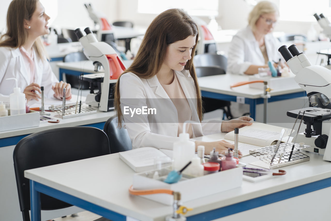 Young female researcher working in science class
