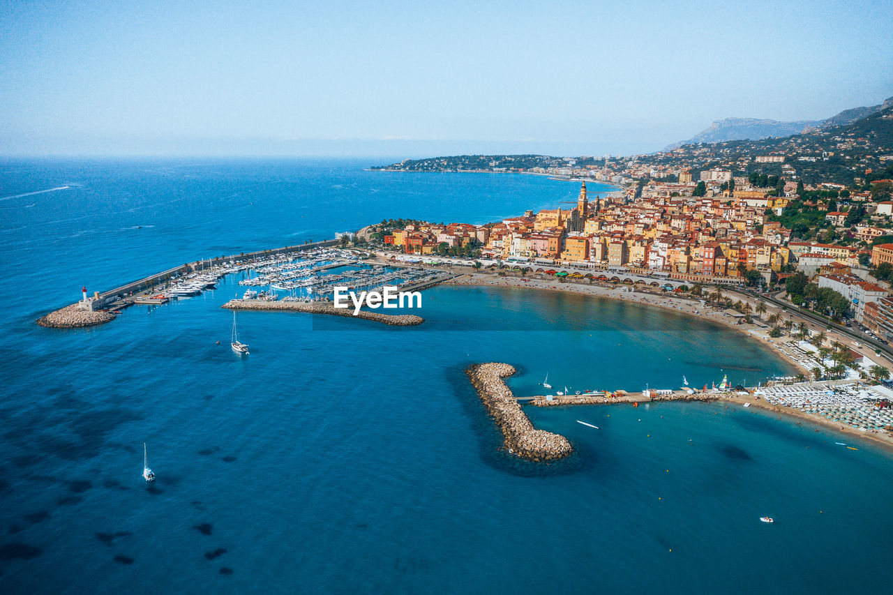 Aerial view of buildings by sea against sky