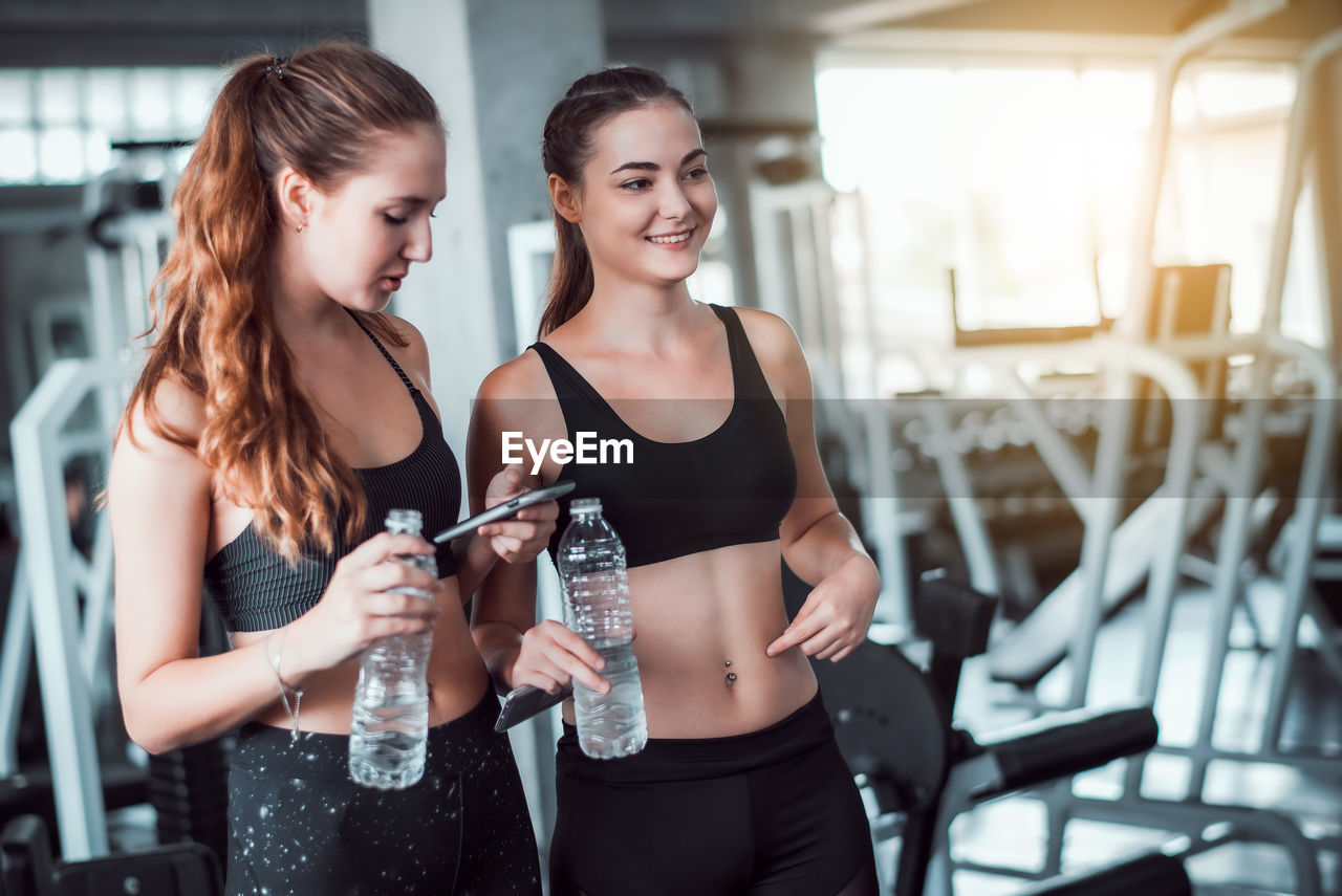 Smiling females standing in gym