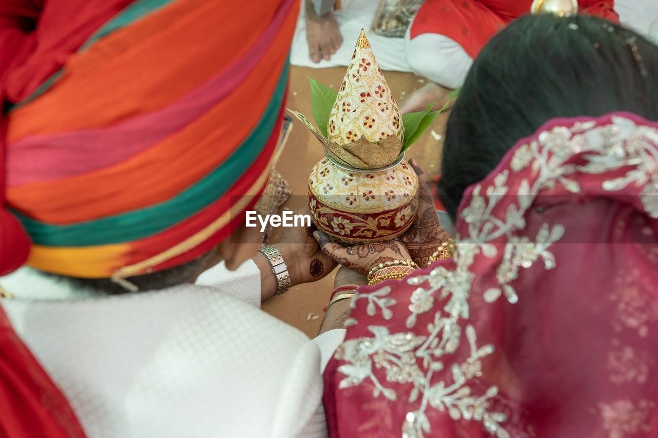 traditional clothing, tradition, clothing, event, celebration, adult, women, ceremony, wedding, life events, wedding ceremony, bride, newlywed, midsection, sari, two people, red, lifestyles, selective focus, traditional ceremony, religion, robe, flower, belief