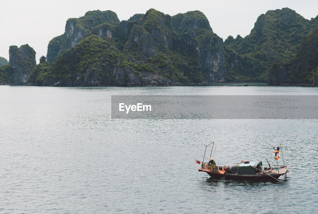 Boat moored on lake against mountains