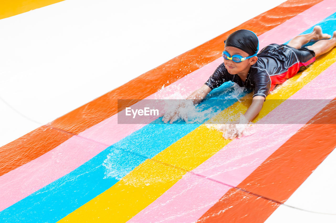 High angle view of boy on water slide in park