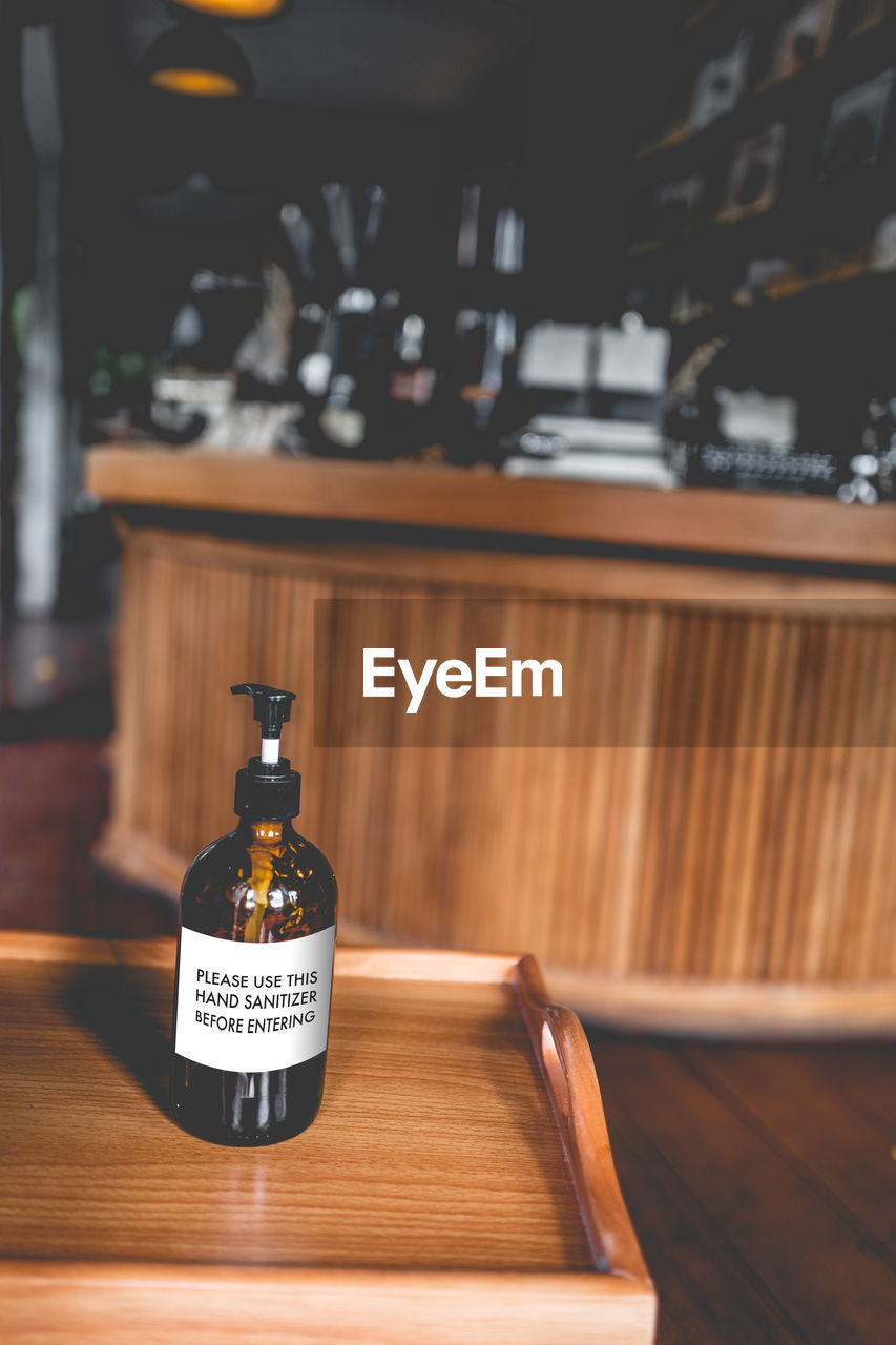 CLOSE-UP OF WINE BOTTLES ON TABLE AT RESTAURANT