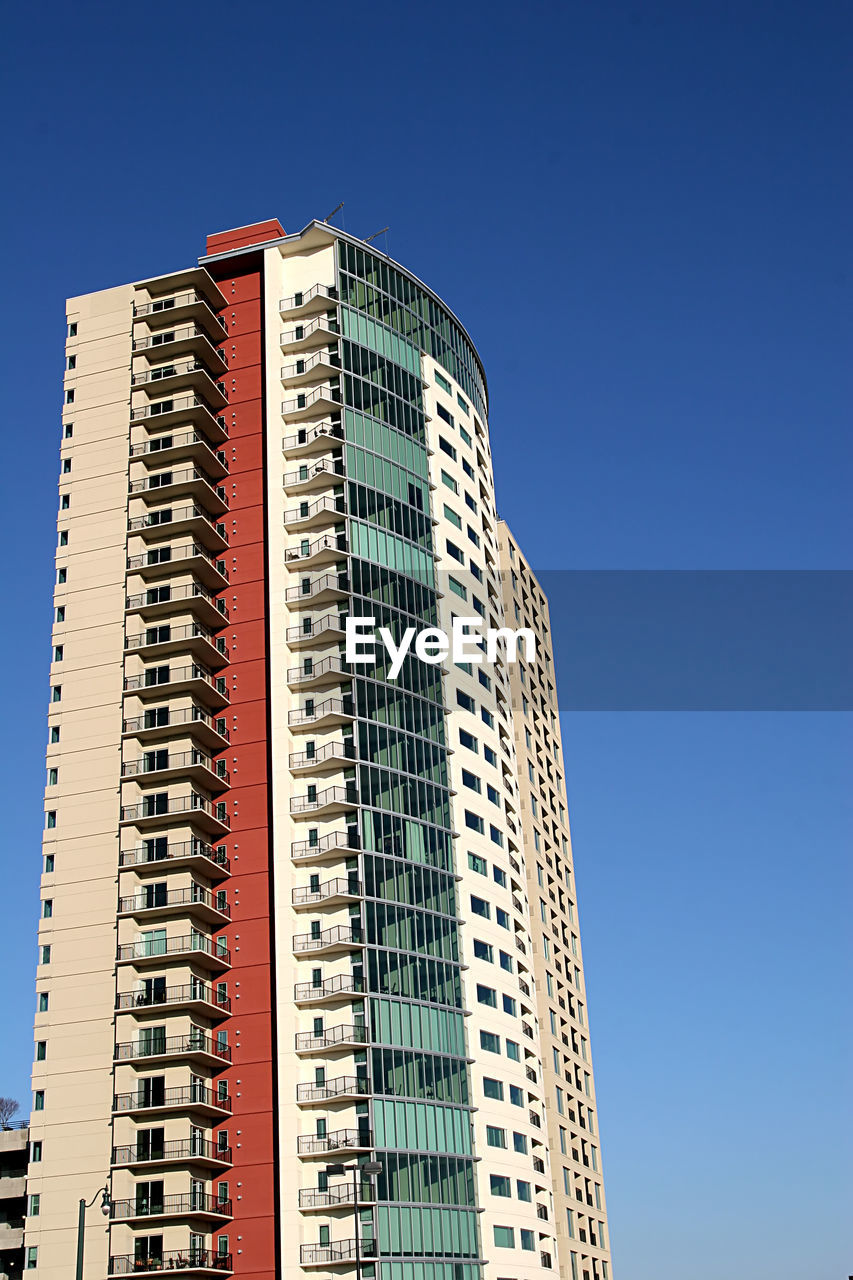 Low angle view of modern buildings against clear blue sky