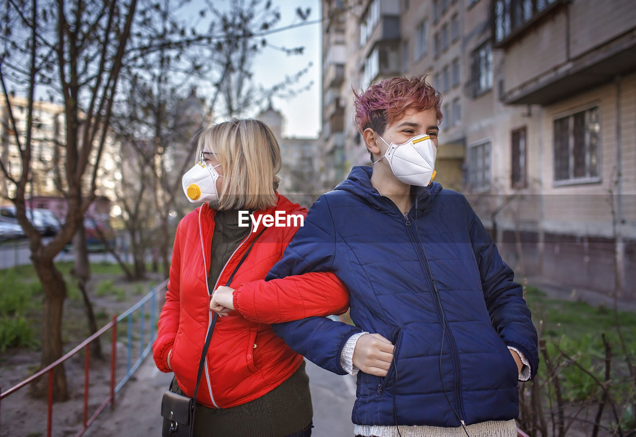 Mother and son wearing mask standing outdoors