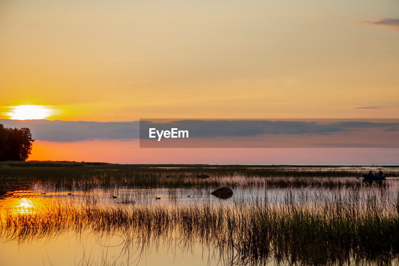 SCENIC VIEW OF LAKE AGAINST ORANGE SKY