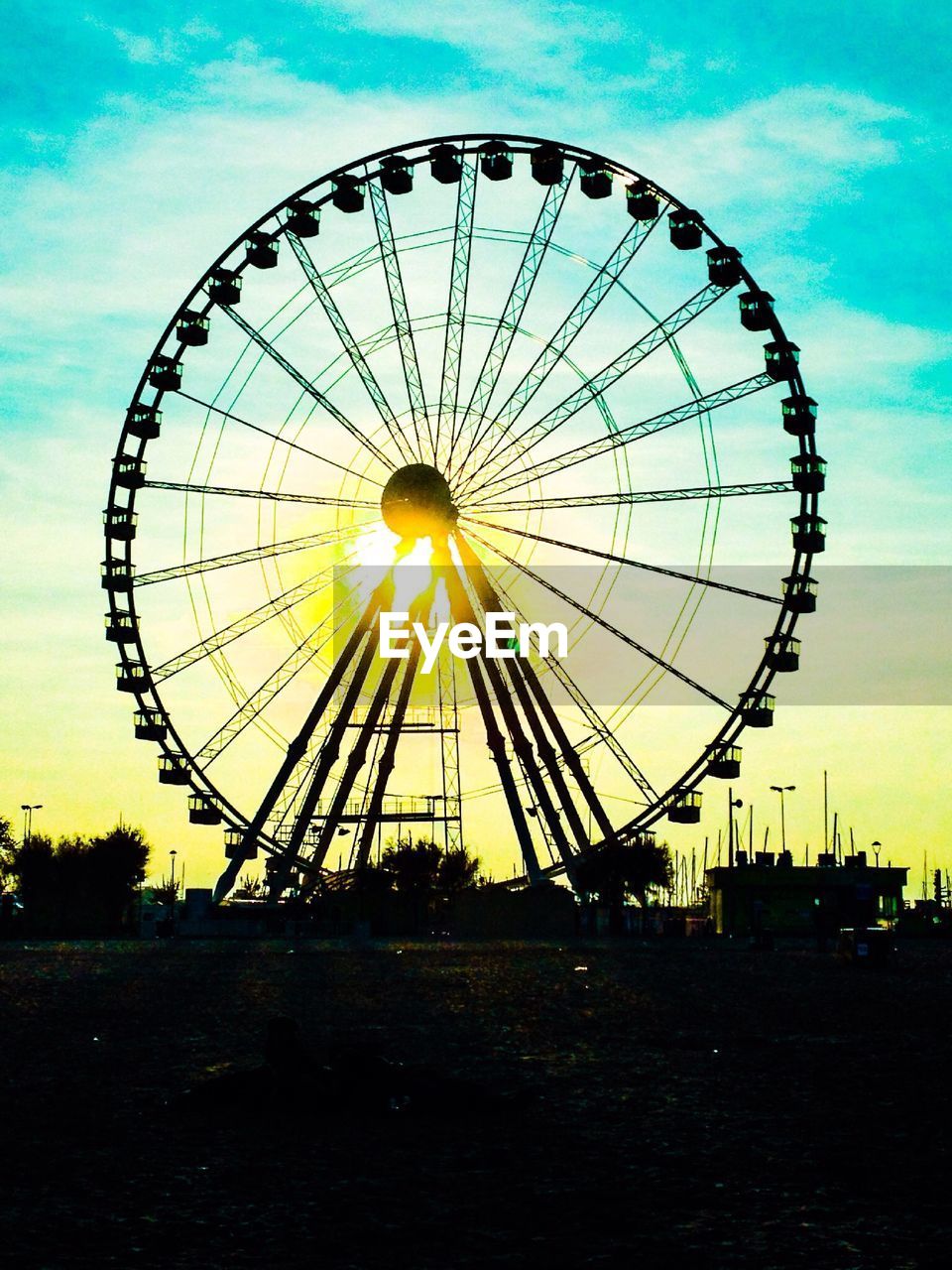 Low angle view of ferris wheel against sky on sunny day