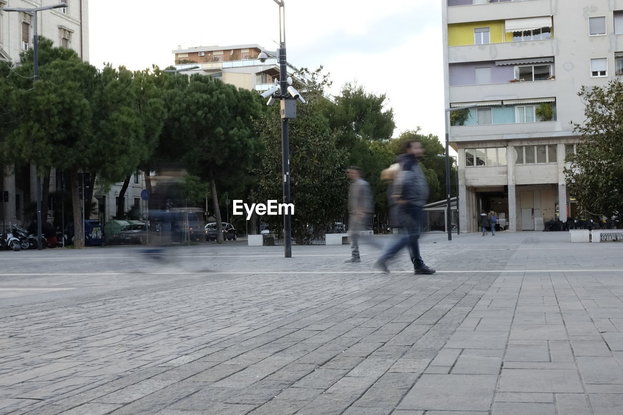 Blurred motion of people walking on street in city