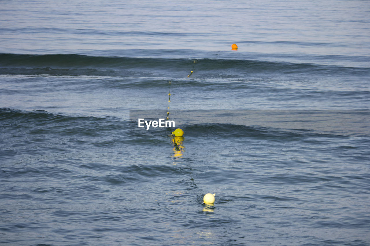 PERSON WITH YELLOW UMBRELLA ON SEA