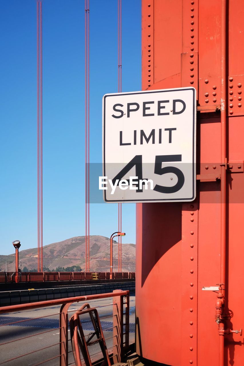 Road sign against clear blue sky