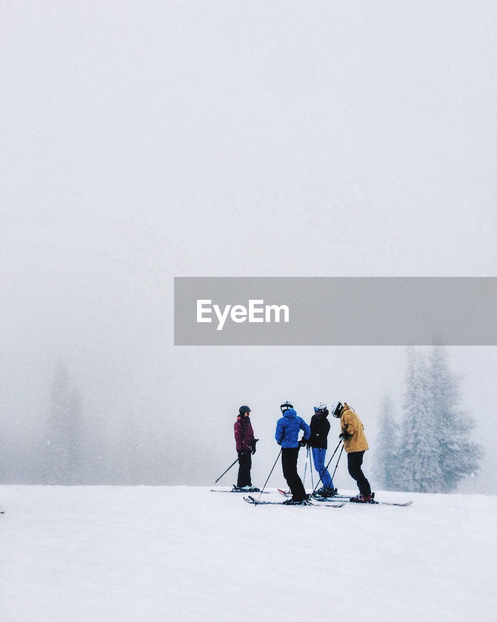 People skiing on hill in foggy weather