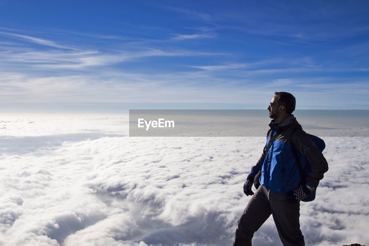 Man standing on snow covered landscape against sky