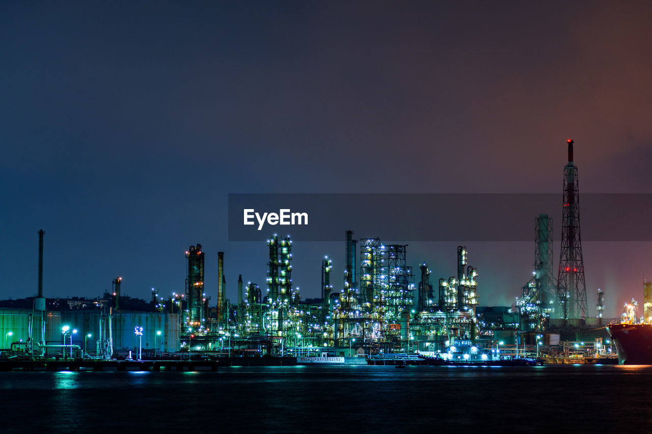 Illuminated cityscape against sky at night