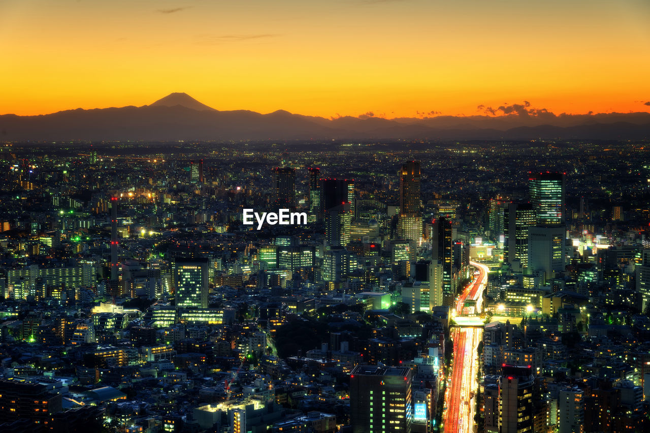 High angle view of illuminated cityscape against sky at night